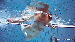 Red haired hottie Martina is stripping under the water