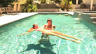 She puts her hand on her pussy in the swimming pool