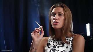 Confident Slim Brunette in a Tight Patterned Dress Enjoying a Slow and Relaxed Smoking Session